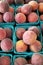 Vertical top view of stack of juicy peaches in blue boxes in the market