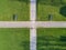 Vertical topview of crossing paths crossway surrounded by green gras