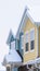 Vertical Townhome exterior with snowy gable valley roof against overcast sky in winter