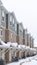 Vertical Townhome facade with snowy gabled roof at the entrance in winter