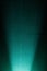 Vertical turquoise scattered light beam on a dark turquoise background in a black dot
