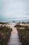 Vertical of two people standing on the beach and enjoying the view of the tranquil seascape