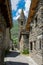 VERTICAL: Unrecognizable traveler observes the medieval stone church in Alps.