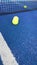 Vertical video, balls bouncing on a blue paddle tennis court