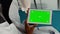 Vertical video: General practitioner holding digital tablet with greenscreen