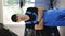 Vertical video portrait of handsome automotive mechanic man in blue uniform and black cap crossed arms standing in