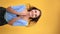 VERTICAL VIDEO POV overjoyed young woman smiling jumping with positive emotion isolated on orange