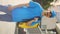 Vertical Video. Smiled Young Caucasian Male Courier Wearing Yellow Backpack And Blue Uniform With a Cap. Handsome