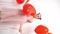 vertical video.teen girl dances, laughs with red balls of hearts near white wall