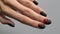 Vertical video with womans hand with trendy fashionable halloween manicure on gray background. Nail design trends.