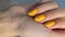 Vertical video with womans hand with trendy fashionable yellow manicure