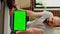 Vertical video: Young freelancer using laptop to work with greenscreen