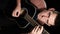 Vertical Video. Young Man Blogger Plays an Acoustic Guitar on a Black Background