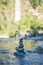 Vertical view of balanced stacked pebbles in a river