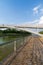 Vertical view of a bridge and fence, over canal with blue summer sky, in Juan Carlos I park in Madrid