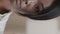 Vertical view close-up half female face serious young african american woman with brown eyes looking at camera vision