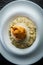 vertical view closeup boiled barley porridge with breaded whole pear