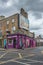 Vertical view of Dublin city street side buildings with shops under the cloudy sky