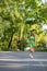 Vertical view of a female wearing tight green shorts, top, and sunglasses while walking in the park