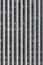 Vertical view of a grid of multiple floors of office windows in a modern concrete, glass and steel skyscraper with white columns