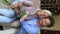 Vertical view happy grownup son cuddles older mom holds flowers