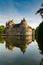 Vertical view of historic Chateau Trecesson castle in the Broceliande Forest with reflections in the pond
