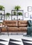 Vertical view of modern coffee house interior with leather settee, small table and plants