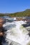 Vertical view of the Namsen River in Namsskogan, Trondelag, Norway, featuring cascades over large stones