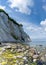 Vertical view of picturesque ocean and coastline with calm clear water and steep white chalkstone cliffs under a blue sky with