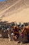 Vertical view of plenty of camels sitting in the desert dressed with colorful apparel and reins. Animal cruelty and