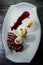 vertical view on restaurant dish of baked sliced duck breast with garnish