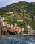 Vertical view of the seaside buildings On the green slope in Cinque Terre