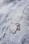 A vertical view of a used respirator lying on snowy ground.