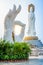 Vertical view of white hand statue with Dharma wheel and Guanyin of the South Sea statue in the background at Nanshan Buddhism