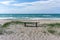 Vertical view of a wooden bench on an idyllic secluded empty beach