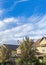 Vertical Whispy white clouds Panoramic residential houses with trees at the front in Daybreak, Utah