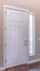 Vertical White hinged wooden front door and sidelight viewed from inside of home