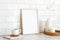 Vertical white photo frame mockup, cup of coffee, vase of dried flowers, candle on wooden table. Nordic, Scandinavian interior