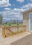 Vertical White puffy clouds Wooden deck of a fenced house with sliding glass door