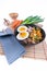 Vertical, wide studio shot of black bowl of ramen noodles with boiled eggs, veggies and turkey meet, ready to be poured