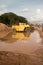 Vertical wide view of muddy roadside construction vehicles with sunny skies