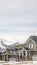 Vertical Winter neighborhood with homes viewed against snowy mountain and cloudy sky