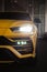 Vertical of Yellow Lamborghini Urus front view with headlights on