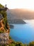 VERTICAL: Young female traveler sits on a ledge and observes the Verdon Gorge