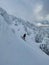 VERTICAL: Young woman shreds fresh powder while snowboarding in backcountry.