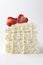 Verticl image.Piece of biscuit cake with slices of strawberry and condensed milk on the white background