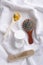 Verticl shot.Wooden spoon full of herbal flowers, brush, comb and moisturizing balm on the white towel