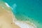 Vertiginous, swirling foamy water waves at the ocean photographed from above cliff.