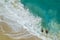 Vertiginous, swirling foamy water waves at the ocean photographed from above cliff.