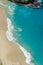 Vertiginous, swirling foamy water waves at the ocean photographed from above cliff.